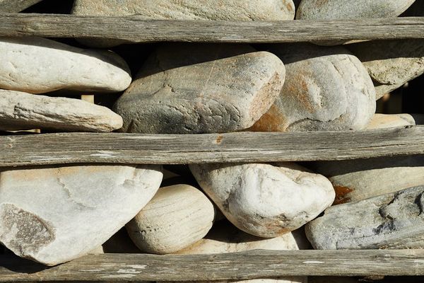 Stack of smooth stones on a wooden surface, representing balance.